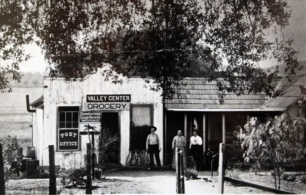 Historic black-and-white photograph of people standing outside a building in Valley Center.