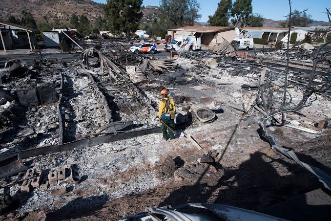 Firefighter Dean Wilson looks for hot spots in the remains of dozens of homes destroyed by the Lilac Fire at a retirement community in Fallbrook.